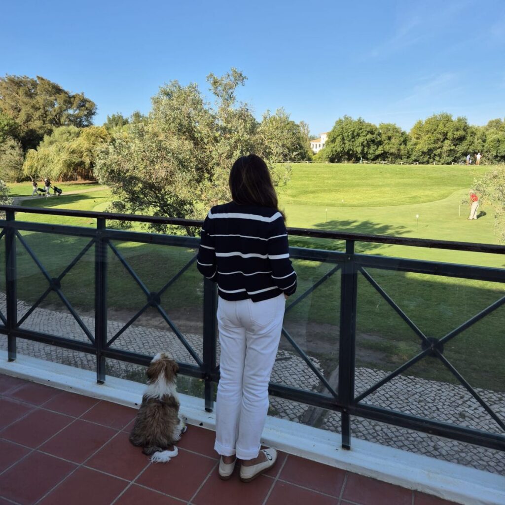 Eu e a Cacau na varanda do hotel a ver os golfistas