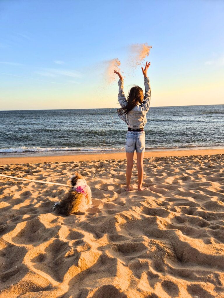 Cacau a brincar com uma criança na praia 